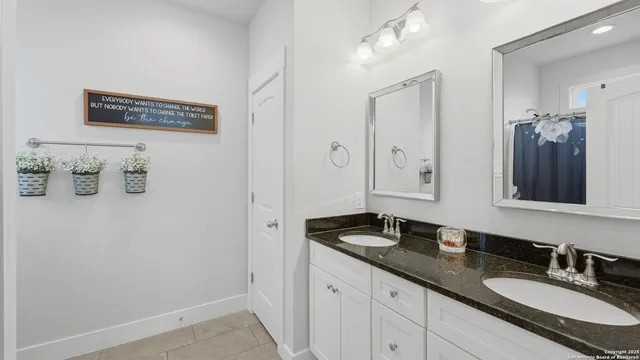 a bathroom with a granite countertop sink and a mirror