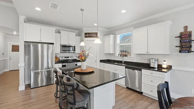 a kitchen with granite countertop a sink appliances a counter space and wooden floor