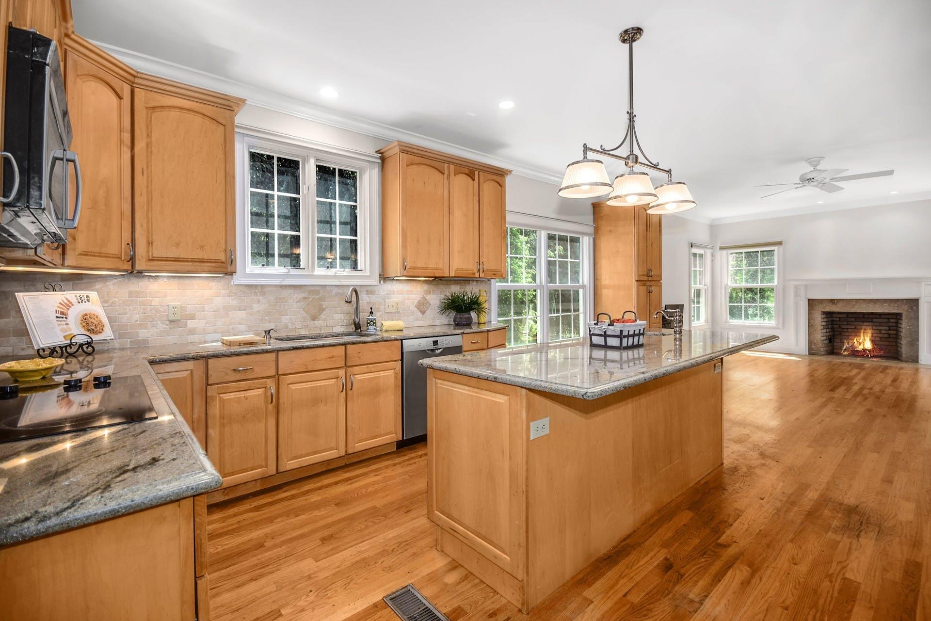 5 Christopher Lane Norwalk, CT 06851 - Photo 19 of 46 a kitchen with stainless steel appliances granite countertop a stove a sink dishwasher and a fireplace with wooden floor