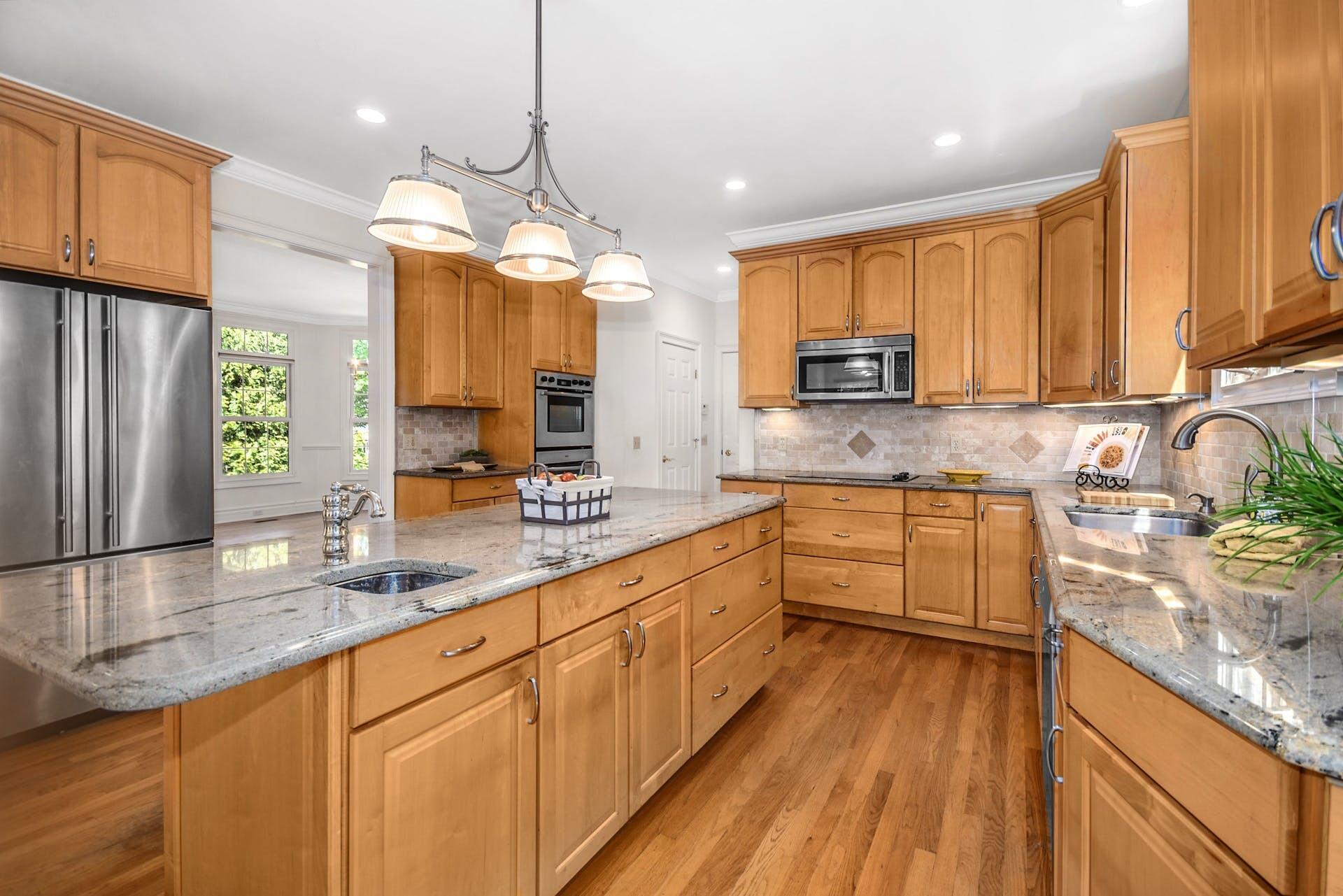 5 Christopher Lane Norwalk, CT 06851 - Photo 20 of 46 a kitchen with stainless steel appliances granite countertop wooden cabinets a stove a sink and dishwasher with wooden floor
