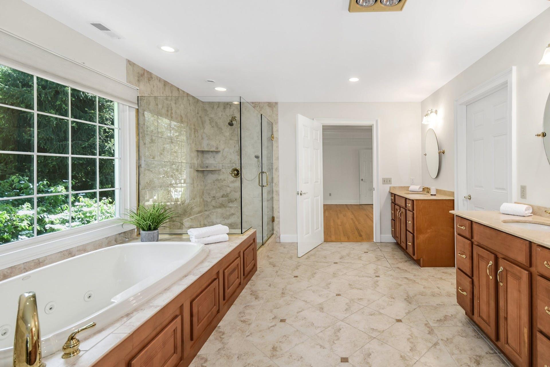 5 Christopher Lane Norwalk, CT 06851 - Photo 24 of 46 a spacious bathroom with a granite countertop tub sink a mirror a shower and a double vanity sink
