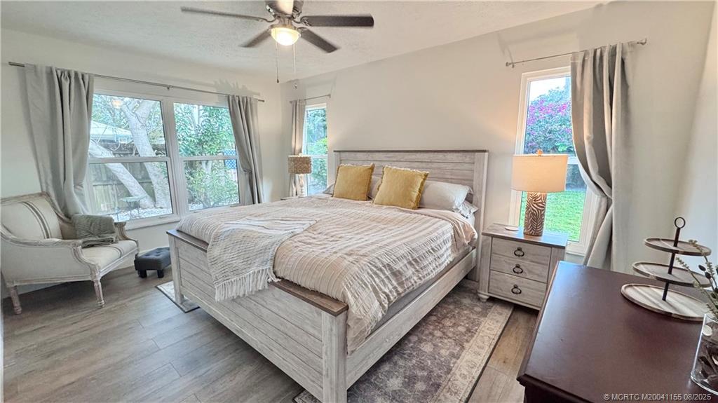 323 Southwest Ridge Lane Stuart, FL 34994 - Photo 17 of 29 a bedroom with a bed a large window with couch and table