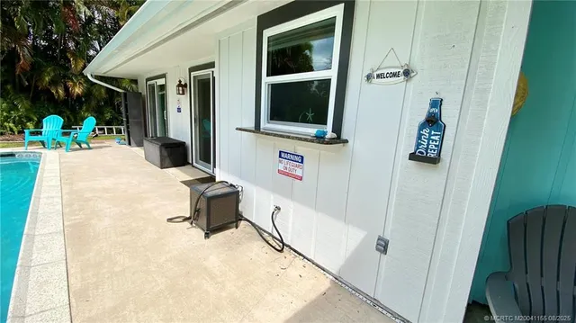 a living room with furniture a flat screen tv and kitchen view