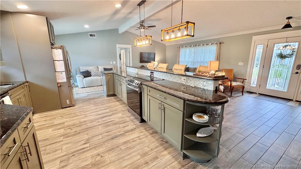 323 Southwest Ridge Lane Stuart, FL 34994 - Photo 9 of 29 a kitchen with stainless steel appliances wooden cabinets a sink and a stove