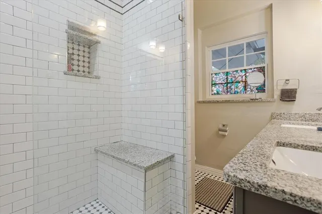 a bathroom with a granite countertop sink a toilet and a shower