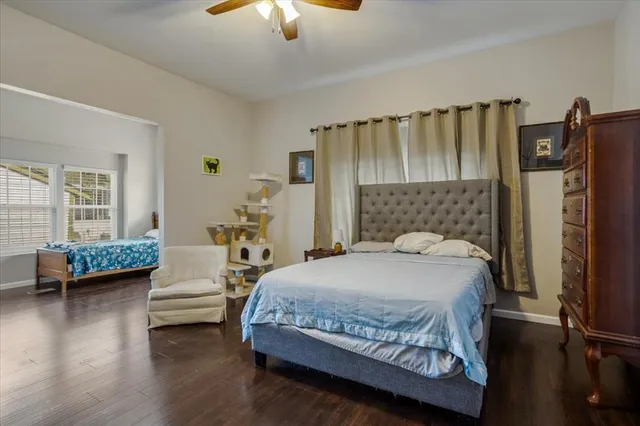 a bedroom with a bed couch and a large window