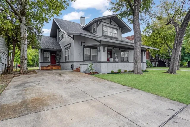 a view of a white house with large windows and a large tree