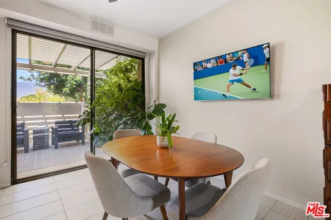 a dining room with furniture potted plants and wooden floor