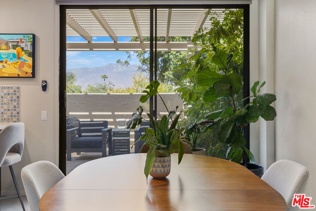 155 Desert W Drive Rancho Mirage, CA 92270 - Photo 19 of 50 a dining room with furniture potted plants and wooden floor
