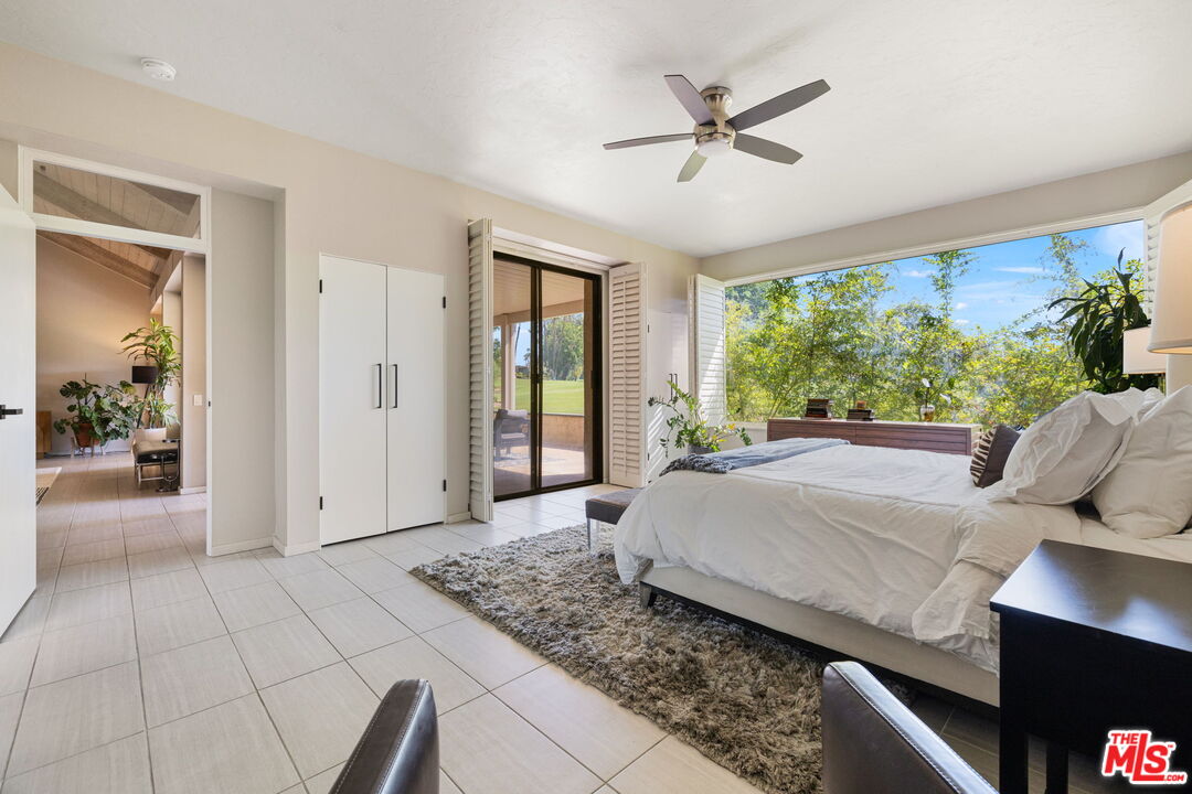 155 Desert W Drive Rancho Mirage, CA 92270 - Photo 29 of 50 a living room with a bed and a large window