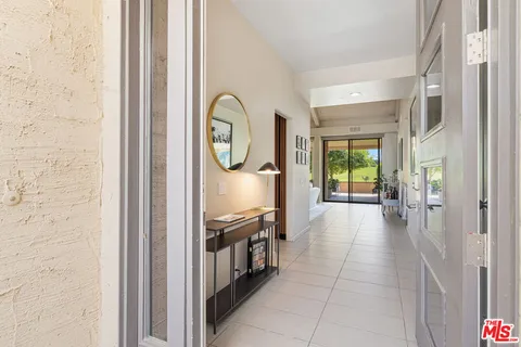 a view of a hallway to a livingroom with furniture