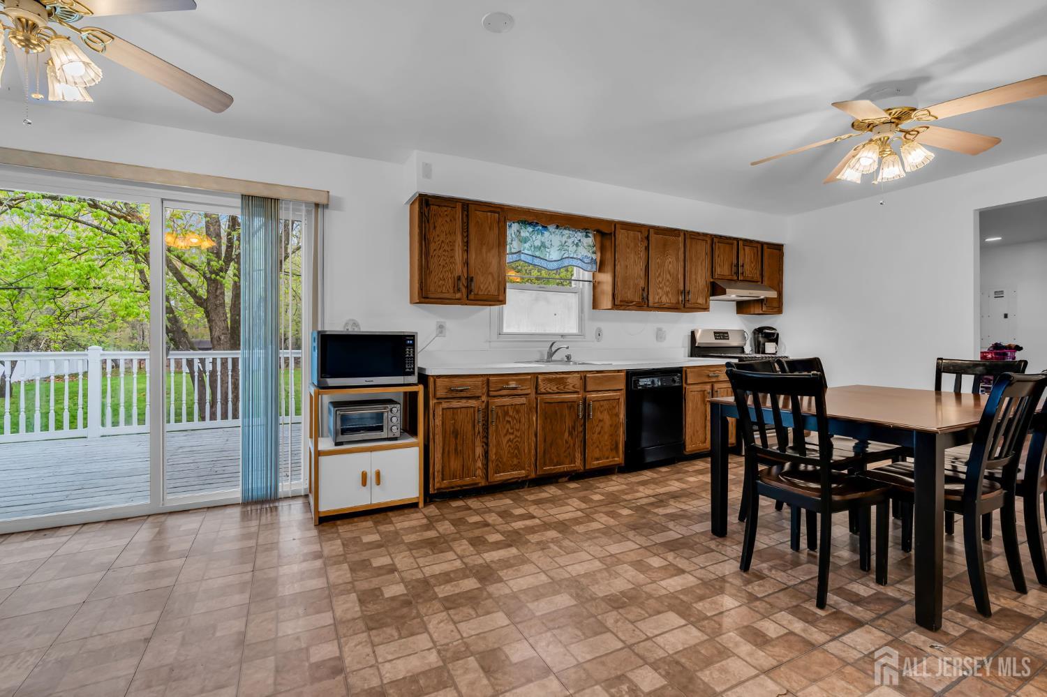 120 Cedar Swamp Road Jackson, NJ 08527 - Photo 8 of 39 a kitchen with a stove a sink a dining table and chairs