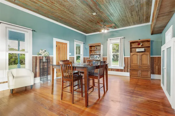a living room with furniture large window and wooden floor