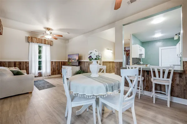 a kitchen with stainless steel appliances granite countertop a stove a sink and white cabinets with wooden floors
