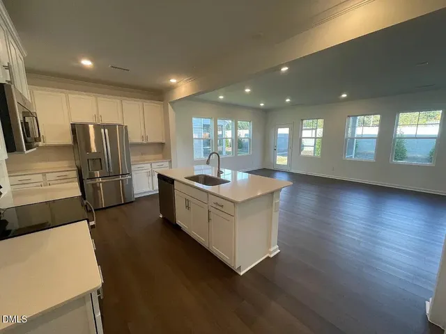 a kitchen with stainless steel appliances a refrigerator sink and stove
