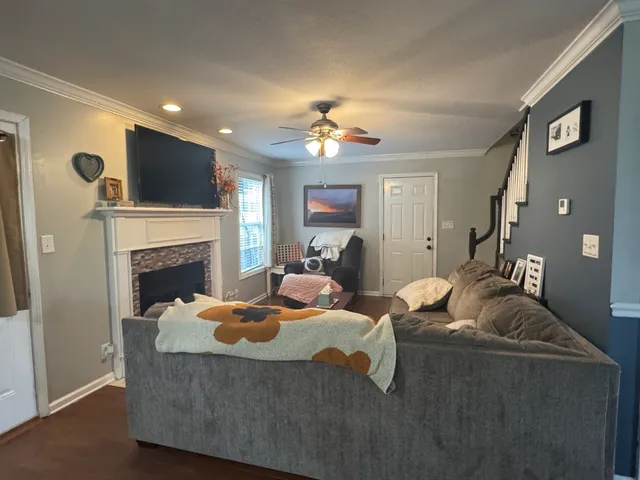 a living room with furniture a flat screen tv and a fireplace