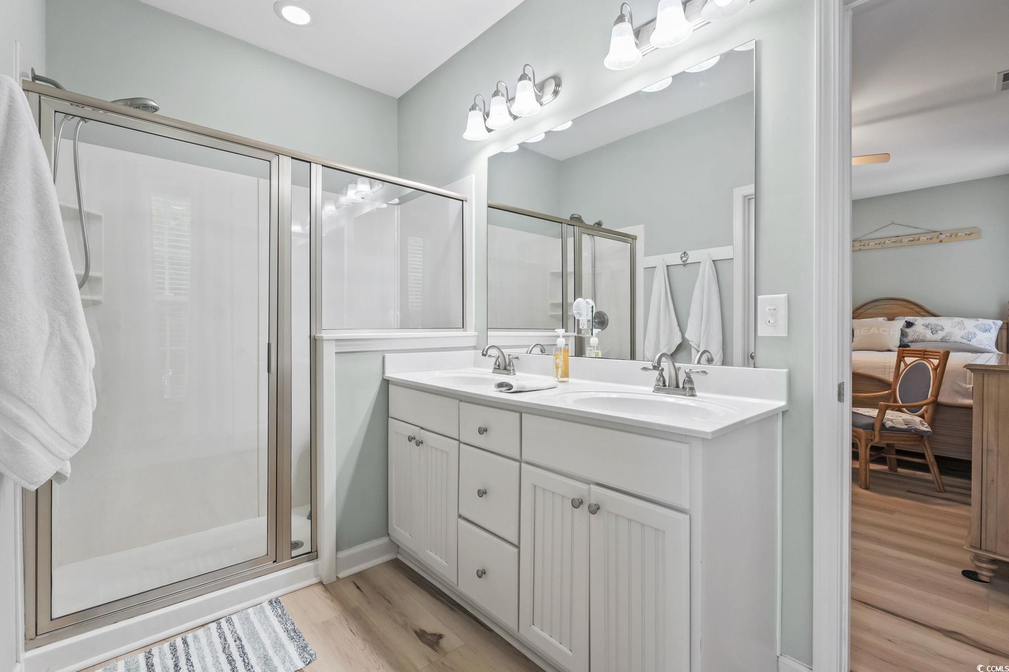 173 Foxpath Loop Myrtle Beach, SC 29588 - Photo 13 of 31 Ensuite bathroom featuring light wood-type flooring, a stall shower, and double vanity