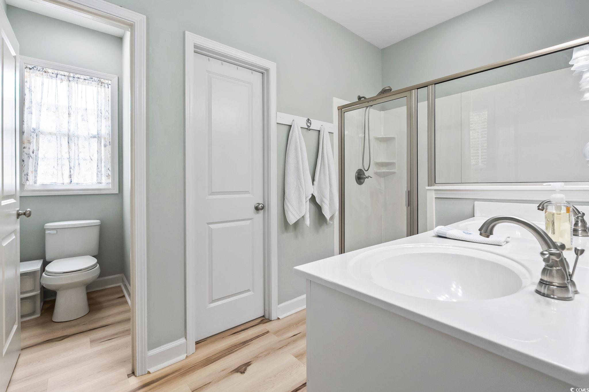 173 Foxpath Loop Myrtle Beach, SC 29588 - Photo 14 of 31 Full bathroom featuring a stall shower, double vanity, and light wood finished floors