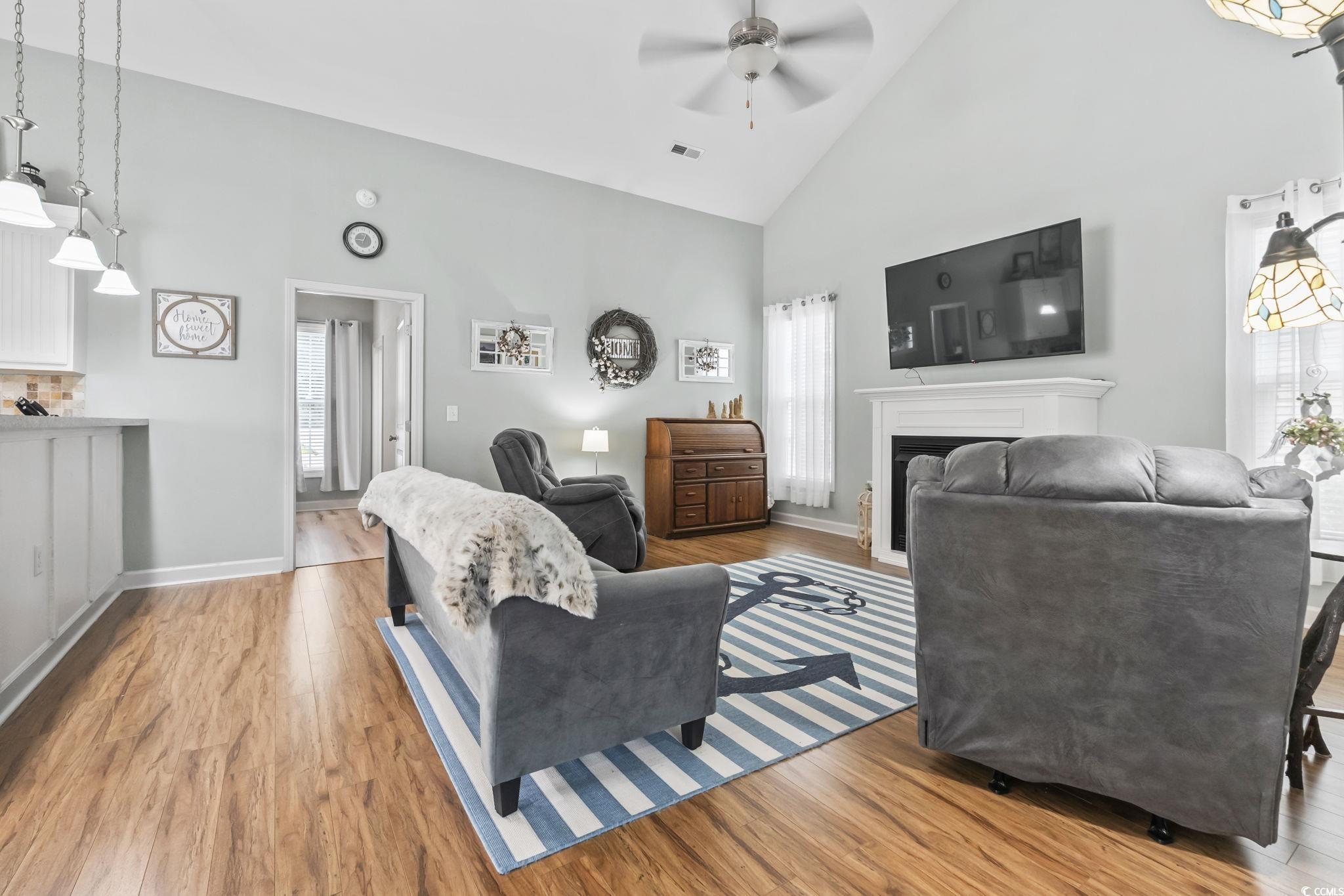 173 Foxpath Loop Myrtle Beach, SC 29588 - Photo 3 of 31 Living area with high vaulted ceiling, light wood-style flooring, a fireplace, and a ceiling fan