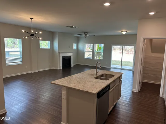 an open kitchen with sink and refrigerator