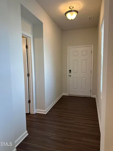 an empty room with wooden floor and mirror