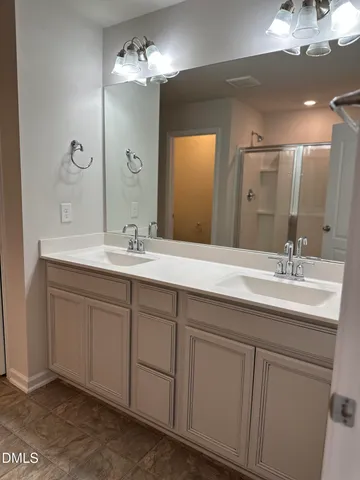 a bathroom with a double vanity sink and a mirror
