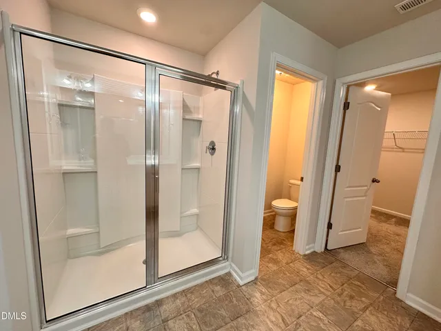 a bathroom with a glass door shower and a sink
