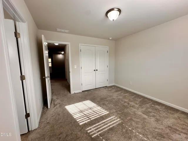 an empty room with mirror and a bench