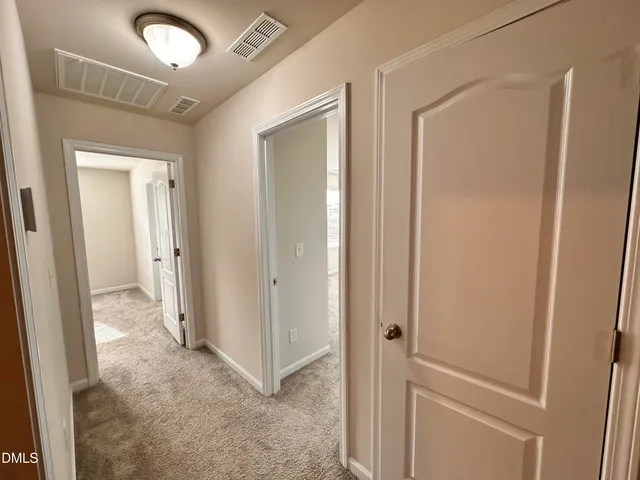 a view of a hallway with closet and wooden floor