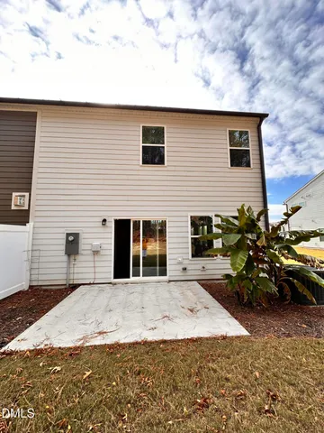 a backyard of a house with wooden fence and some plants