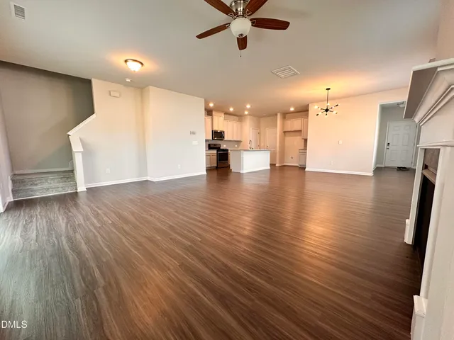 a view of empty room with wooden floor and windows