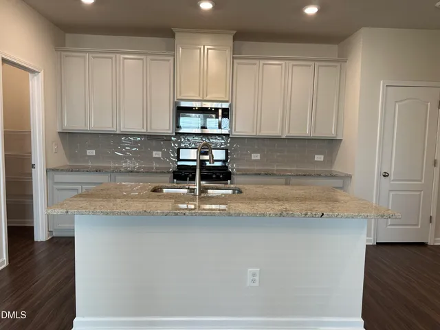 a view of a kitchen with granite countertop stainless steel appliances