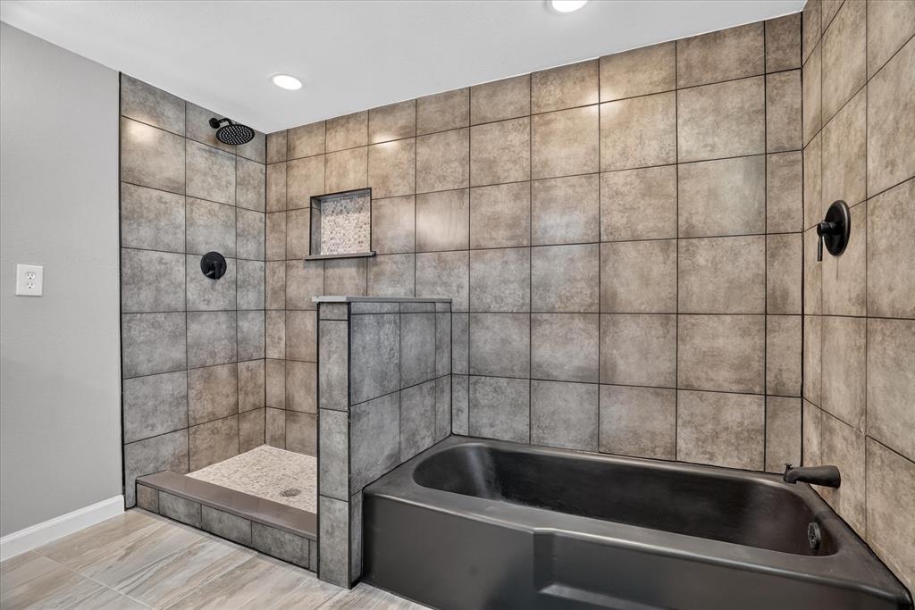 130 R And R Drive Springtown, TX 76082 - Photo 23 of 40 Walk-in shower with tiled walls and floor, complete with a built-in niche and rainfall showerhead
