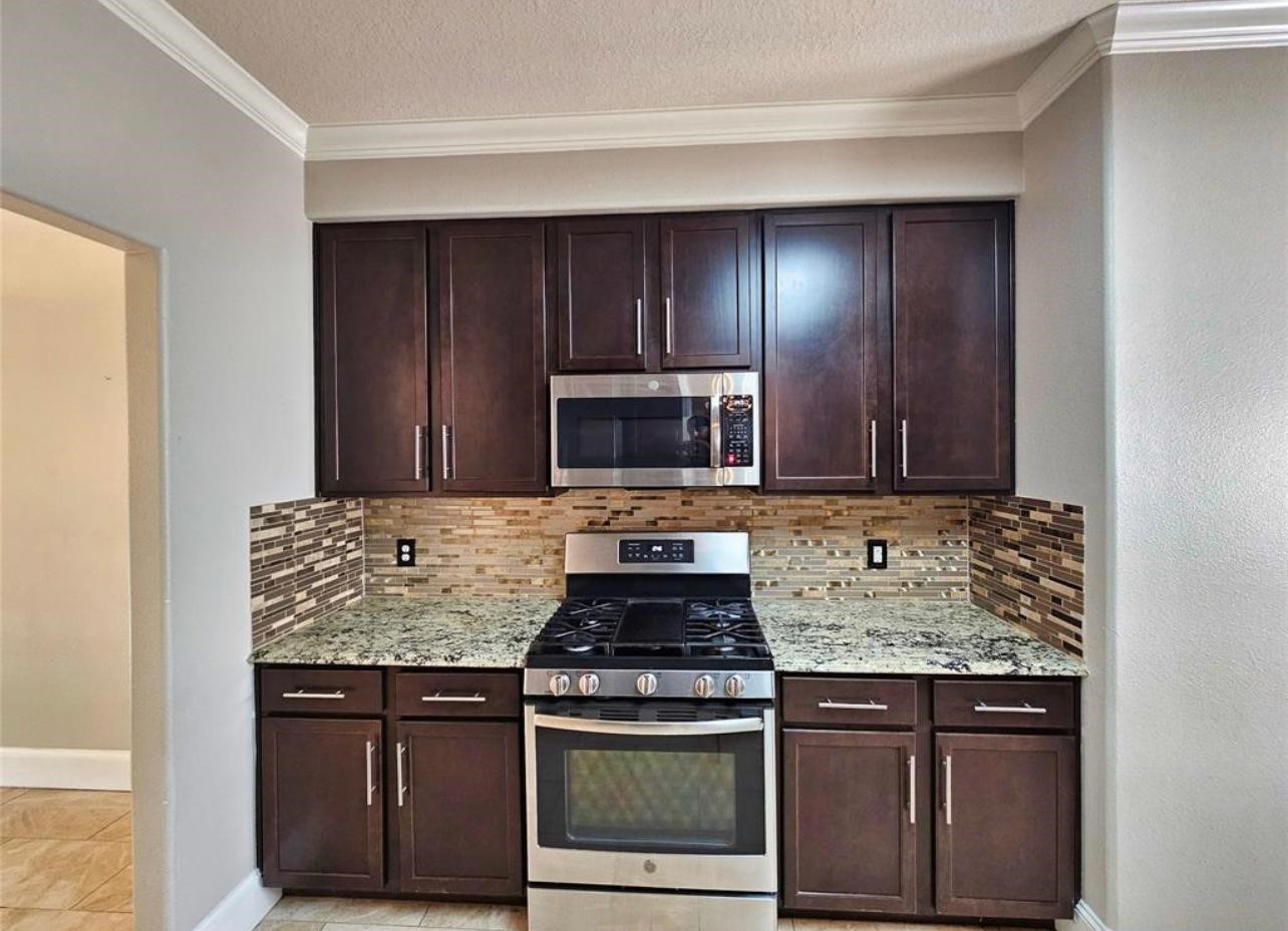29433 Forest Ln Spring Spring, TX 77386 - Photo 15 of 18 a kitchen with stainless steel appliances granite countertop a stove and a microwave
