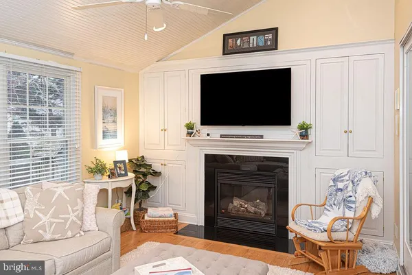 a living room with furniture and a dining table with wooden floor