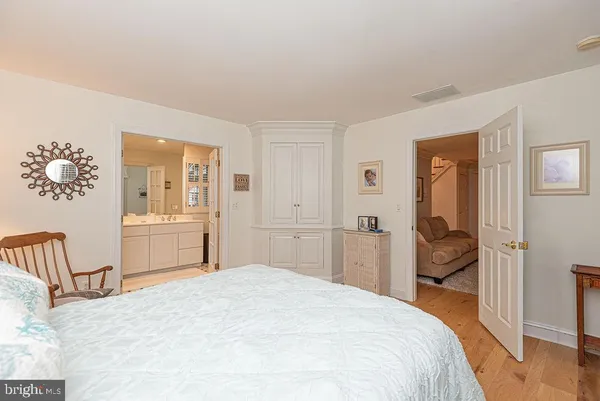 a view of a bedroom with wooden floor and cabinet