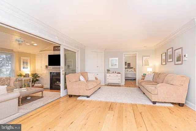 a living room with furniture and a dining table with wooden floor