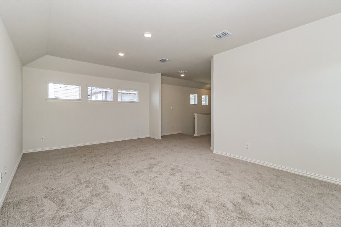 530 Ansley Court Taylor, TX 76574 - Photo 9 of 31 Spare room with light carpet, recessed lighting, and lofted ceiling
