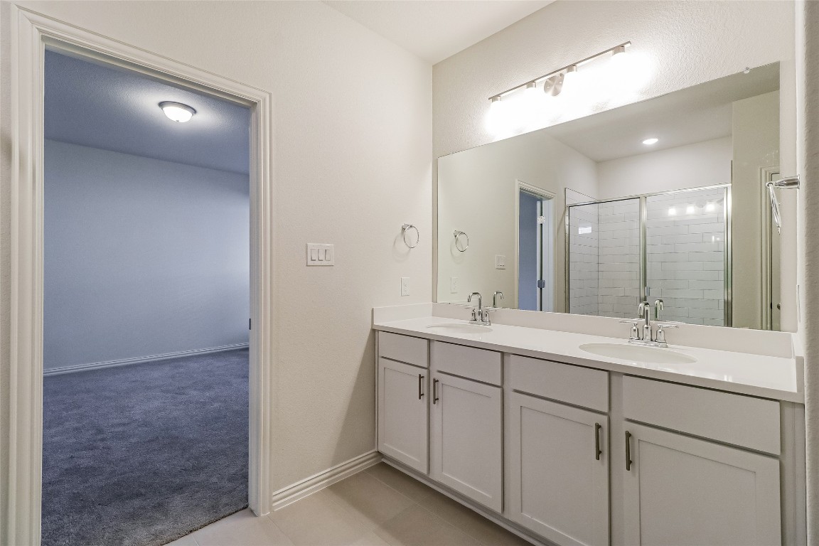 530 Ansley Court Taylor, TX 76574 - Photo 12 of 31 Full bath featuring a shower stall, double vanity, and light carpet