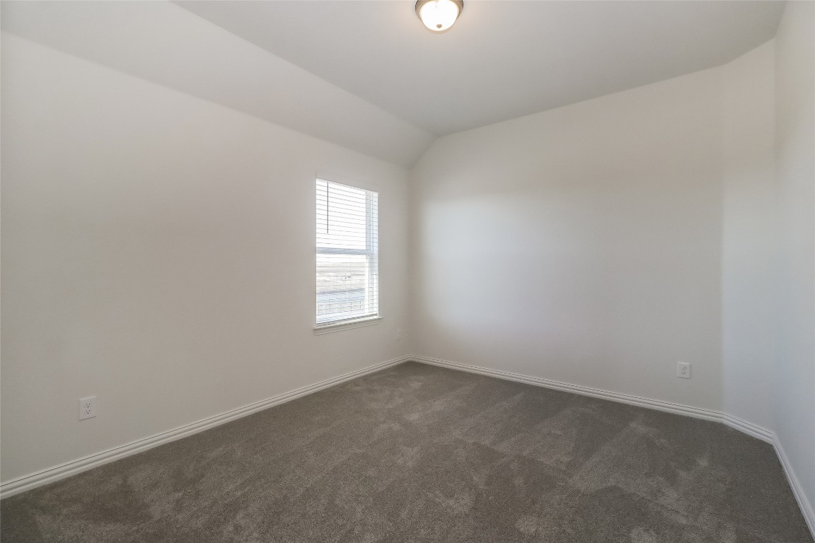 530 Ansley Court Taylor, TX 76574 - Photo 15 of 31 Unfurnished room with vaulted ceiling and dark colored carpet
