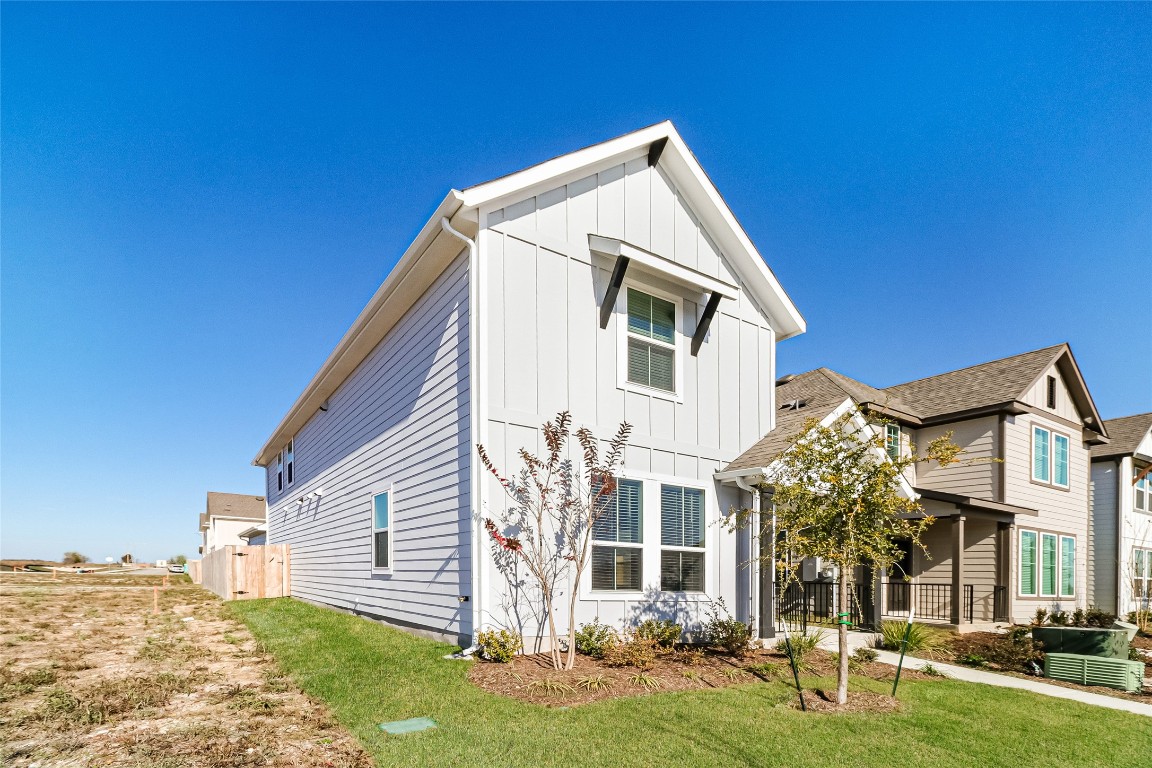 530 Ansley Court Taylor, TX 76574 - Photo 2 of 31 View of front of home with board and batten siding, a front lawn, and covered porch