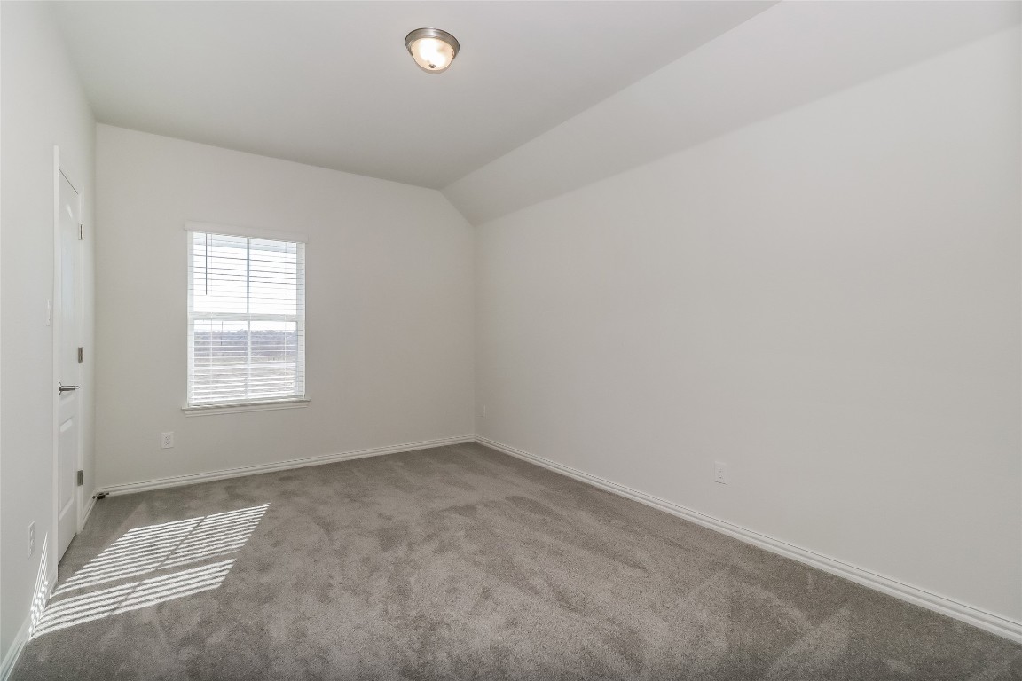 530 Ansley Court Taylor, TX 76574 - Photo 22 of 31 Empty room with carpet flooring and lofted ceiling