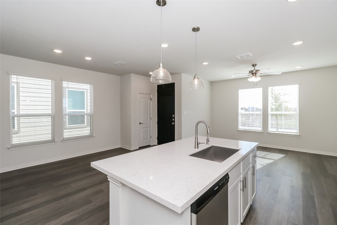 530 Ansley Court Taylor, TX 76574 - Photo 31 of 31 Kitchen featuring open floor plan, pendant lighting, stainless steel dishwasher, white cabinets, and dark wood-type flooring