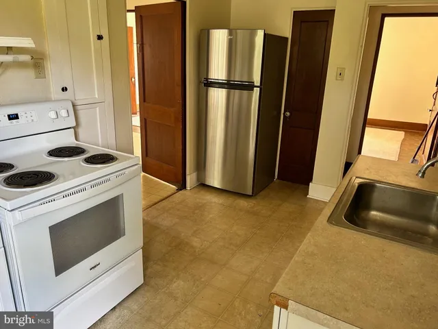 a kitchen with a refrigerator sink and stove