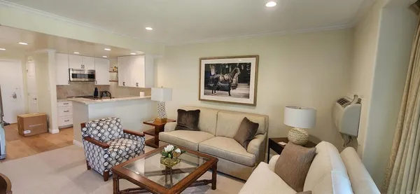 a living room with furniture and a view of kitchen