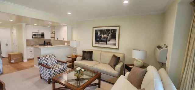 a living room with furniture and a view of kitchen