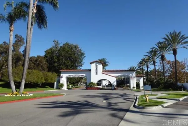 a front view of a house with garden and trees