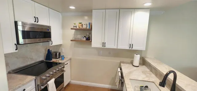 a kitchen with stainless steel appliances a refrigerator a stove a microwave and cabinets