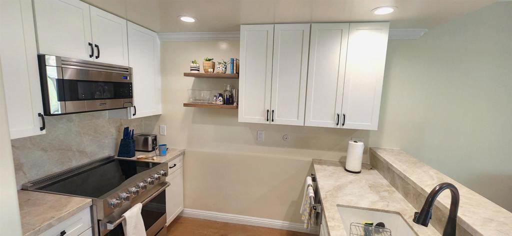 2005 Costa Del Mar Road, Unit 619 Carlsbad, CA 92009 - Photo 10 of 23 a kitchen with stainless steel appliances a refrigerator a stove a microwave and cabinets