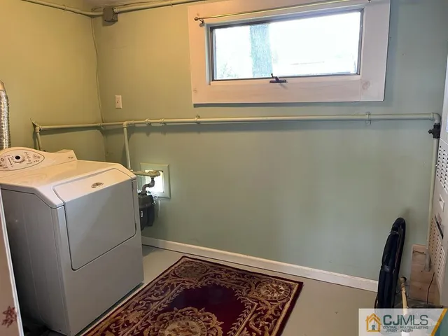a utility room with dryer and window